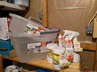 Photo showing 15L translucent bucket with handle, matching storage caddy, multiple glass cleaning bottles with dispensers and labeled liquids on shelf.
