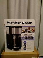 Front view of the Hamilton Beach Home Barista 7-in-1 coffee maker box showing the product image, brand name, and key features.