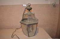 Front view of the large exterior hanging lamp showing its polygonal glass panels and metal frame.