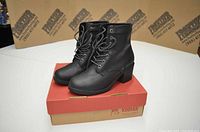 Pair of black leather women's boots on top of a red and beige Kodiak brand shoe box.