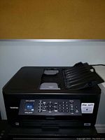 Front and top view of the Brother MFC-J497DW printer showing the LCD screen, control buttons, and input/output trays.