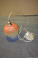 Single glass pendant lamp with gradient color shade in orange, beige, and blue, showing 6-ft white cord and mounting hardware.