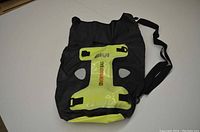 Givi 30L black and yellow waterproof bag seen from the front with shoulder strap and holding buckles.