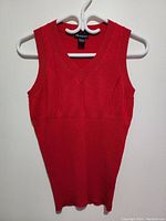 Full front view of red sleeveless sweater vest, showing overall length and fit shape on hanger.