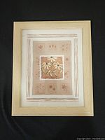 Full view of framed floral print art with beige mat and light wood frame