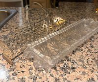 Photo of two antique candy holders: clear crystal rectangular dish and silver holder with ornate handle and decorative sides