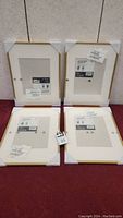 Four new IKEA gold photo frames, 12x16 inches, with packaging and protective corners visible.