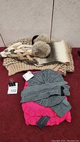 Photo showing beige chunky knit scarf, cream and brown ombre scarf, fluffy gray ear muffs, pink and gray scarves