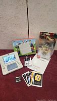 Open white New Nintendo 3DS system with Mario box, sealed Bowser amiibo, game cartridge, AR cards, quick start guide
