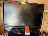42-inch RCA flat screen TV with remote and smart TV adapter in front, showing the full screen and base.