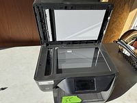 Top view of open flatbed scanner showing glass surface and lid interior