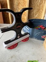 Loopz electronic game with LED lights and white stand, next to Beyblade battle arena.