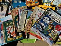 Photo showing a stack of assorted children's books with visible titles such as The Little Critter's Christmas, The Night Before Christmas, Bears Christmas, Stone Fox