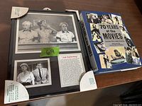 Framed black-and-white photo showing scenes of Lucille Ball and Desi Arnaz from I Love Lucy with a green sticker labeled 69 and a text panel about the "Job Switching" episode. Frame corners are protected with white paper covers.