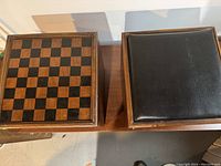 Top view showing checkerboard game board and black cushioned seat on two wooden cube storage seats