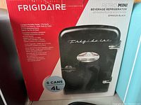 Box showing front of Frigidaire Retro Mini Beverage Refrigerator, model EFMS129, black color, 4L capacity for 6 cans