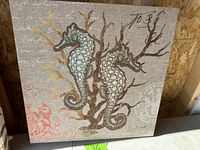 Wall panel with two seahorses on a coral and script background.