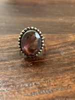 Front view of the sterling silver ring with an oval amethyst stone showing the faceted cut and beaded bezel.