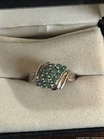 Top view of the sterling silver ring showcasing the emerald cluster centerpiece with flowing silver accents.