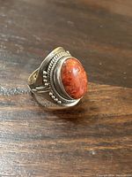 Side angle showing the ring's stone, detailed braided silver accents, and band structure.