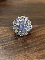 Top view of sterling silver tanzanite ring showing central round stone surrounded by pear and marquise tanzanite stones with silver beaded detailing