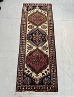 Full view of the rectangular Persian Ardebil rug showing the triple medallion pattern and border design on a light floor.