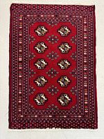 Full view of the rectangular rug showing the entire geometric pattern and border on red background.