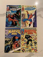Four vintage Marvel comics from the 1980s including two Official Marvel Index to The Amazing Spiderman issues and two Marvel Age news magazines