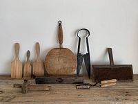 All items arranged on white background showing lot contents including butter paddles, cutting block, sheep shears, level, hair waver, scribe, and wool carding comb.