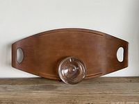 Glass ashtray placed near the center and a wooden serving tray with integrated handles visible