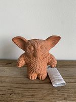 Front view of Gizmo Chia Pet planter with instructions rolled beside it.