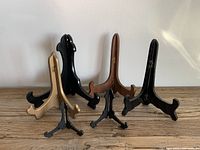 Six frame/plate holders arranged in two rows showing size and color variations on a wooden surface.