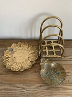 Three vintage brass decor pieces: footed shell dish, sunflower brass dish, napkin/letter holder