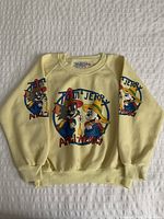 Front view of the yellow vintage Tom & Jerry kids sweatshirt showing the character graphic on chest and sleeves
