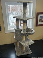 Full view of gray cat tree showing multiple levels and platforms with window in background