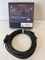Boxed Ruipro 8K Fibre Active Optical HDMI Cable and coiled cable on table.