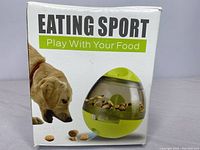 Boxed packaging showing product branding and depiction of the pet food dispenser toy with a dog interacting.