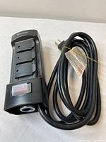 Front view of black Kasonic extension cord showing 3 outlets with safety covers, on/off switch, and coiled cable