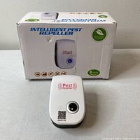 Photo of the box and one ultrasonic pest repeller device in front.