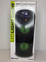 Photo of the Sylvania party tower speaker in its original packaging showing front view with LED light features labeled.