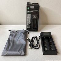 Complete lot setup including Fugasun USB multi-battery charger, USB Type-C charging cable, and gray drawstring pouch.