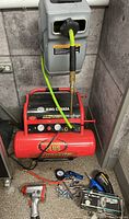 Compressor with accessories laid out on floor