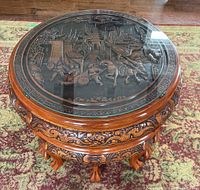 Full view of round table showing carved apron, legs and glass top