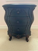 Front view showing bombe profile, three drawers and round drawer pulls