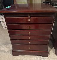Front view of wooden side table with six brass ring pull drawers