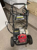 Front view of Karcher pressure washer with hoses and engine visible