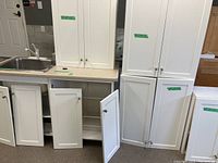Overall view of sink installed in countertop with base cabinets and adjacent tall cabinets