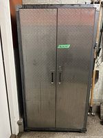 Front view of metal storage cabinet with diamond plate finish and two doors.