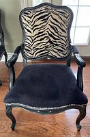 Front view showing black velvet seat and zebra-print upholstered back with silver nailheads