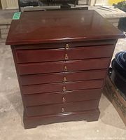 Front view of side table showing seven drawer faces with brass bail pulls.